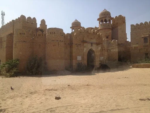 "Tourists enjoying Suratgarh desert adventures on sand dunes at sunset"