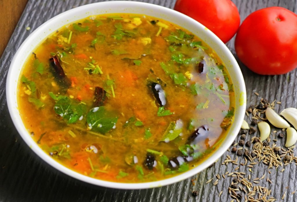 "Bowl of spicy Miryala Rasam made with black pepper, garlic, and tamarind."
