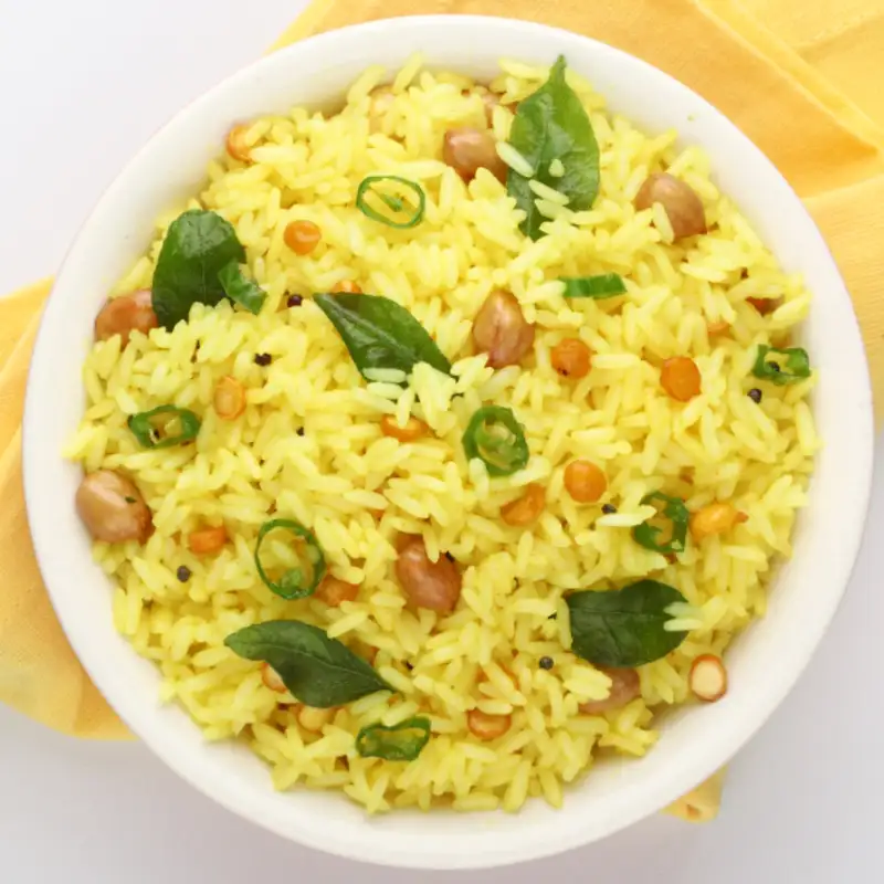 "A plate of Pulihora, a tangy South Indian tamarind rice dish garnished with curry leaves and peanuts."